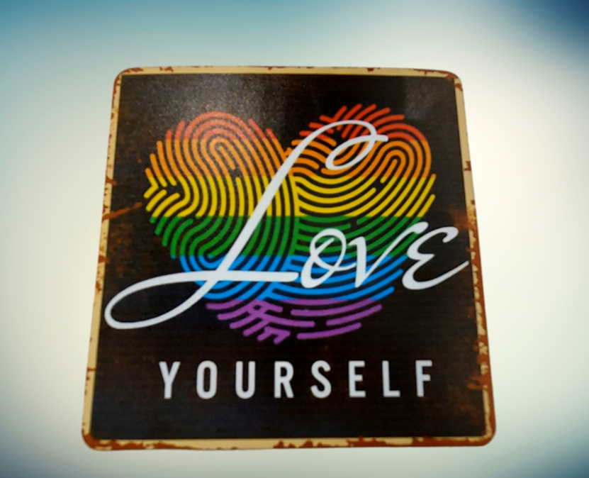 Der Magnet zeigt den Schriftzug „Love Yourself“ vor einem herzfoermigen Fingerabdruck in Regenbogenfarben. Das Wort „Love“ ist in geschwungener Schrift über das Herz gelegt, darunter steht „YOURSELF“ in Großbuchstaben.