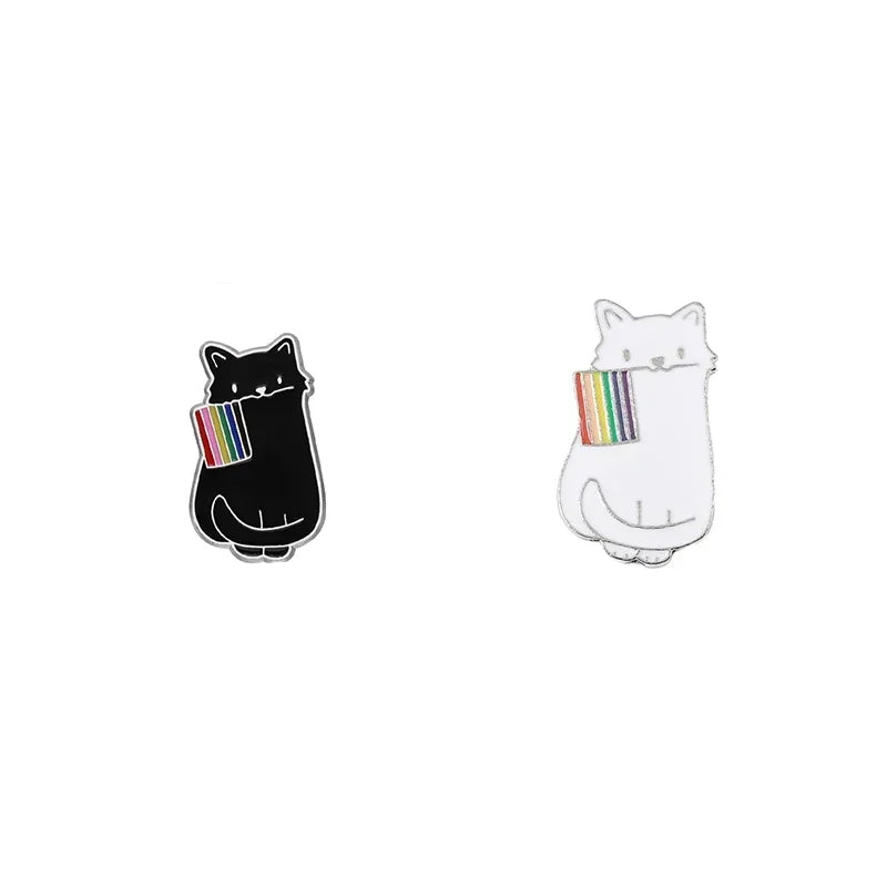 Dieser einzigartige Pin zeigt eine schwarze und eine weisse Katze, die stolz eine LGBTQI+-Regenbogenflagge im Mund tragen. Das Design vereint die kraftvolle Symbolik der Regenbogenflagge mit der geheimnisvollen Eleganz der Katze, wodurch ein ausdrucksstarkes Accessoire entsteht. Perfekt, um an Jacken, Taschen oder Rucksaecken ein Statement für Vielfalt und Akzeptanz zu setzen!