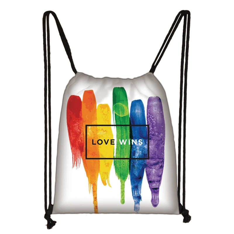 Weißer Turnbeutel mit Regenbogen-Pinselstrich-Design und der Aufschrift ‚Love Wins‘, symbolisch für LGBTQ+ Stolz und Liebe.