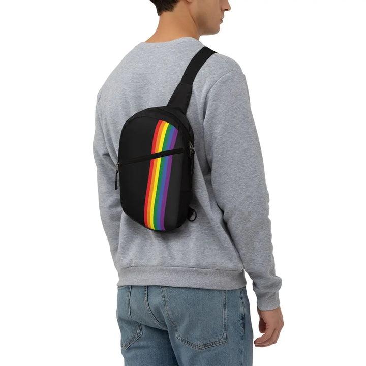 Moderner Crossbody-Rucksack in Schwarz mit stilvollem Regenbogenstreifen-Design. Ausgestattet mit mehreren Reißverschlusstaschen und einem verstellbaren Gurt für Komfort und Funktionalität. Perfekt für Alltag, Reisen oder Pride-Events